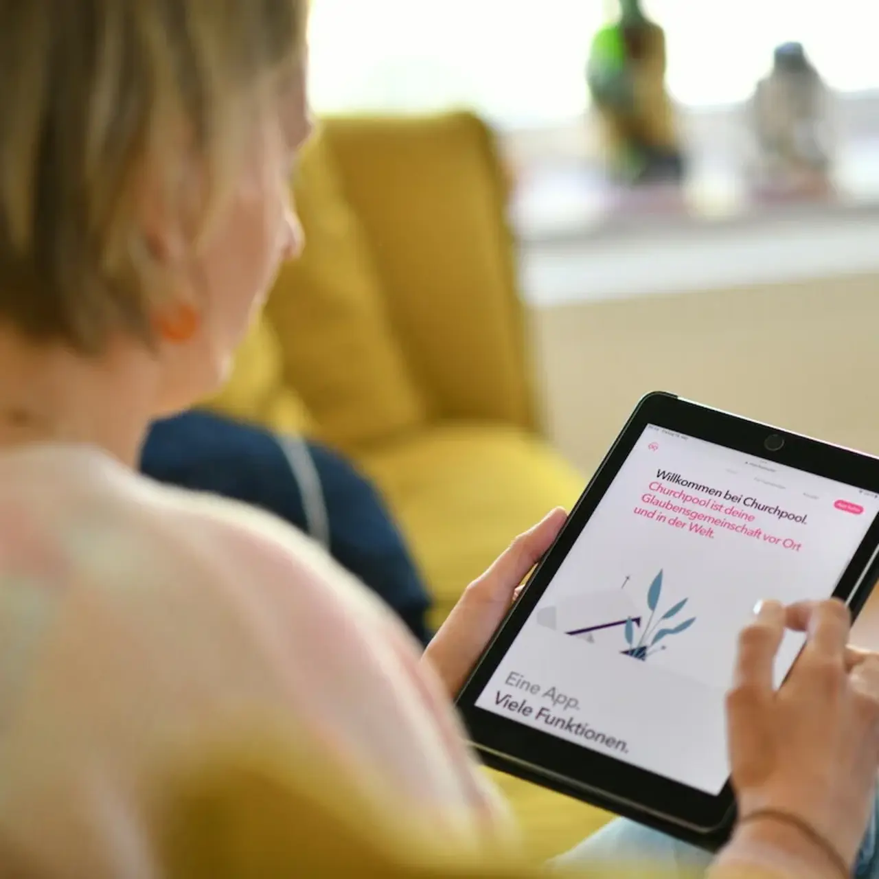 Frau blickt auf ein Tablett auf dem die Website Churchpool geöffnet ist.