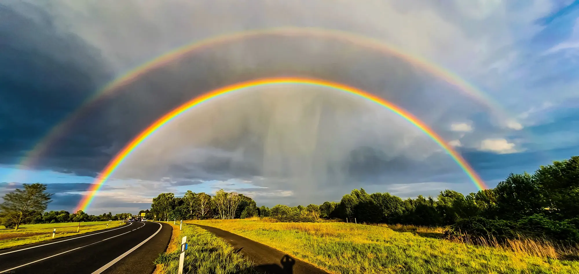 Doppelter Regenbogen über einer Straße